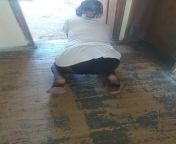 Woman in hijab wipes the floor in the village house from house wiping boy an